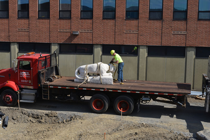 lion statue on flatbed truck being taken to new site