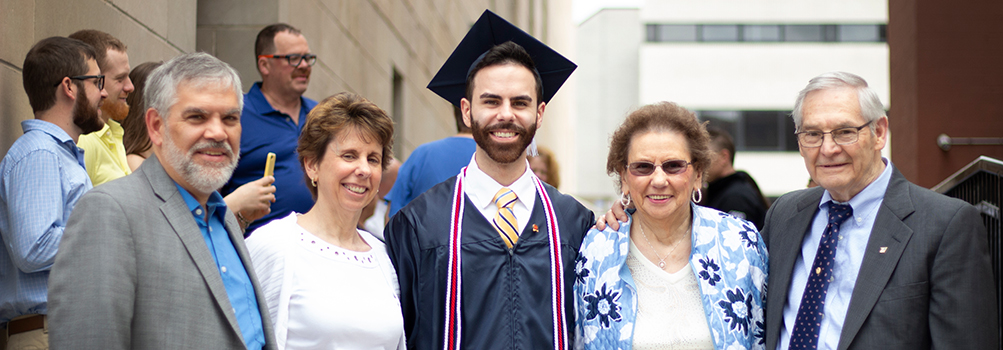 Graduate pictured with his parents and grandparents at Commencement.