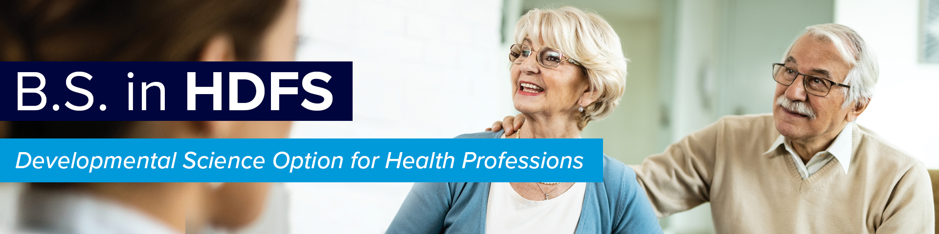 smiling elderly couple speaking with a health professional