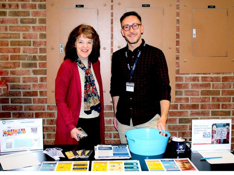 Disability services director Eileen Giovagnoli and Matt Smith man a table with information on disability services