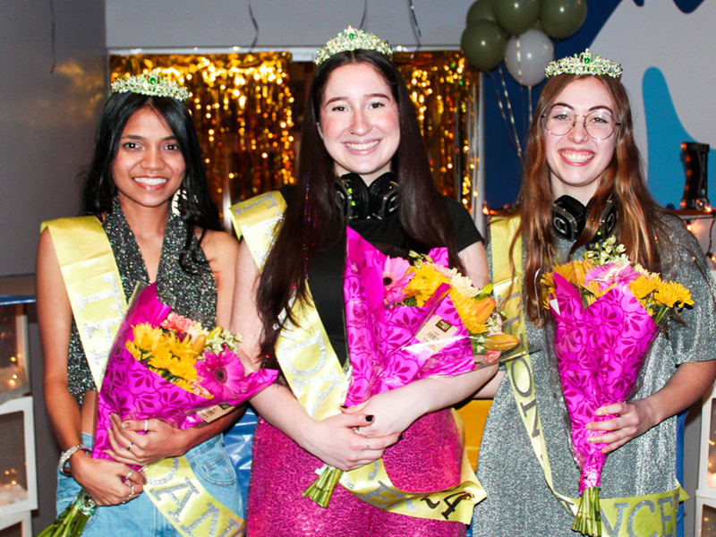 The three female students chosen as dancers pose for a photo at the reveal, holding flowers