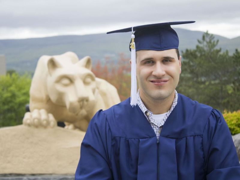 Student wearing commencement regalia and smiling