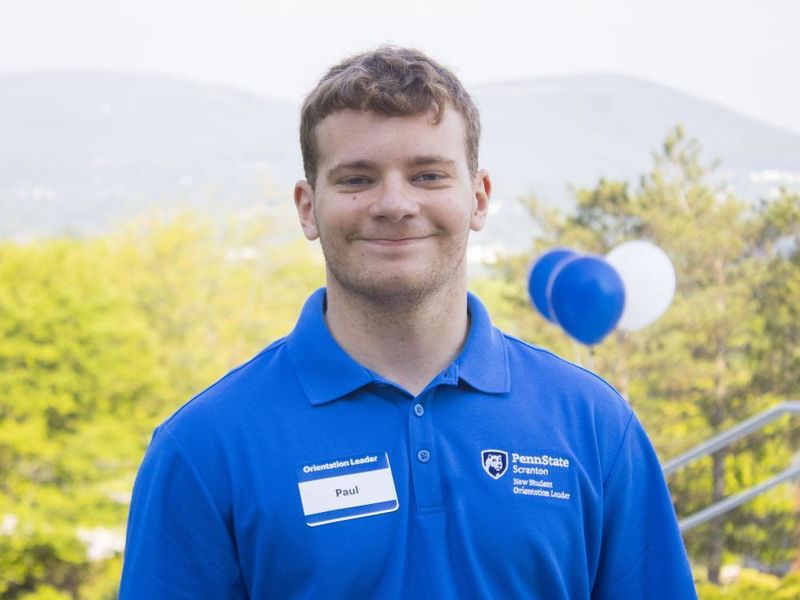 NSO Leader, Paul, smiles with balloons in the background. 