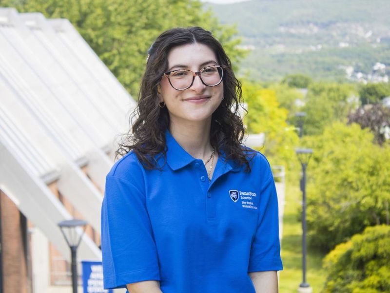 Student smiling with mountains in the background