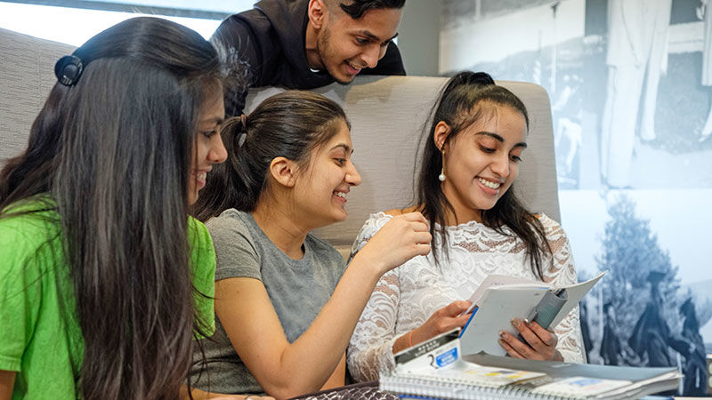 four students gathered together laughing