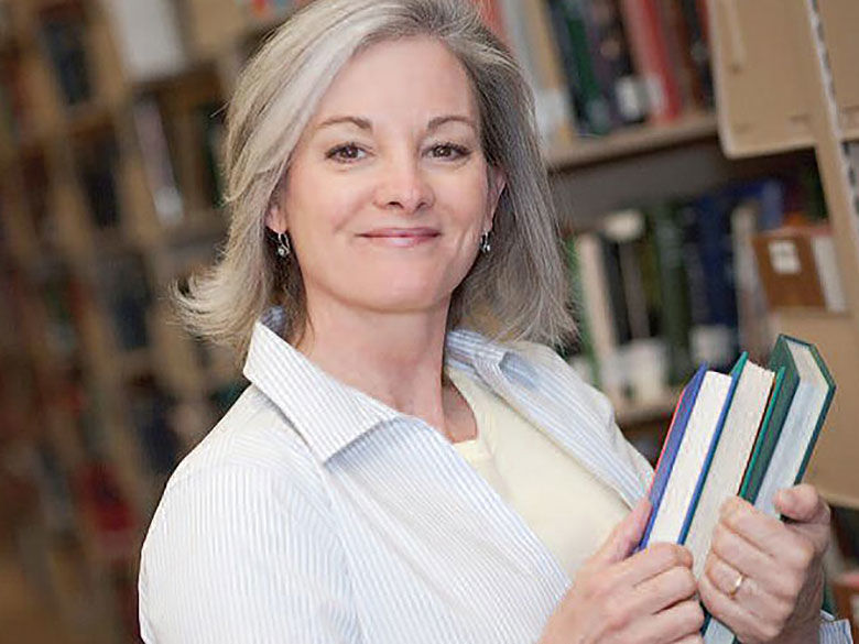 smiling professional with books in library