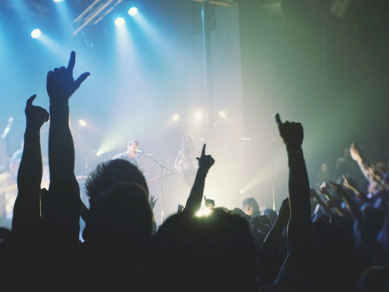 large crowd at a concert watching a band on stage