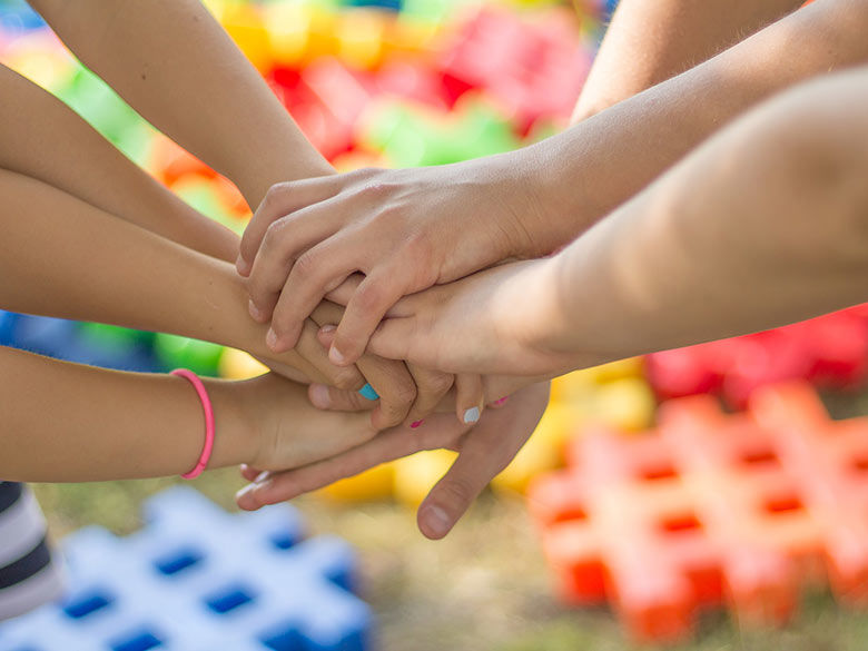 children stacking hands in unity