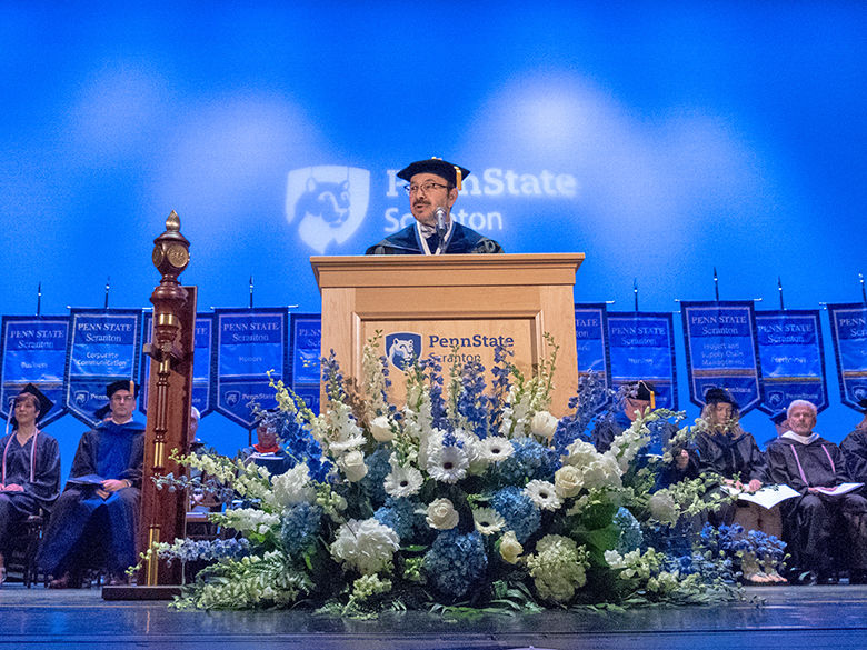 chancellor in cap and gown standing at a podium
