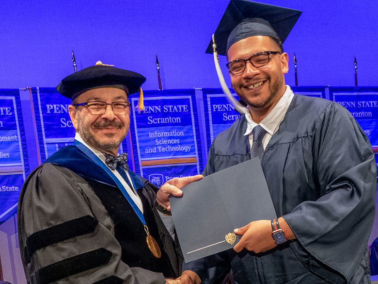 smiling graduate receives diploma 
