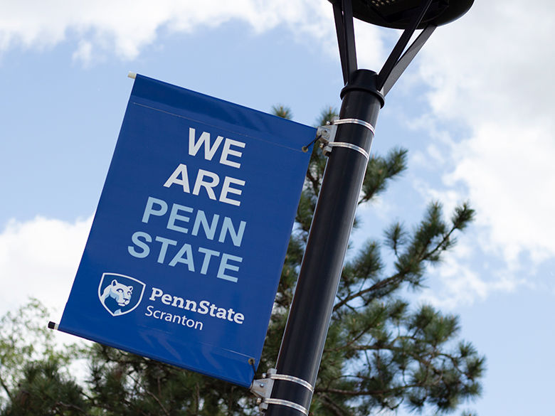 We Are Penn State banner hanging on a light pole.
