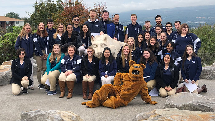 Large group of students with the Nittany Lion mascot near the Lion Shrine.