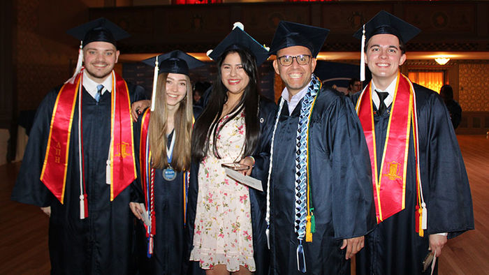 group of 5 students in commencement garb