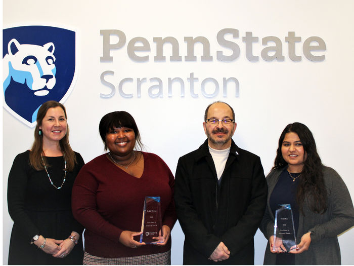 Chancellor Marwan Wafa poses for a photo in front of Penn State Scranton logo on wall with Diversity award winners