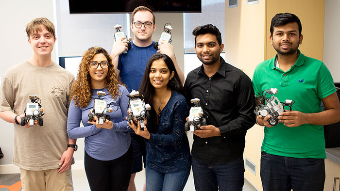 six students holding Lego robots