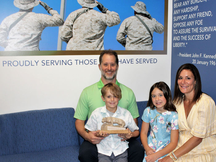 campus donors E.J. and Aryn Long, sit on a sofa in the new Penn State Scranton Veterans Lounge with their children, Addison and Parker