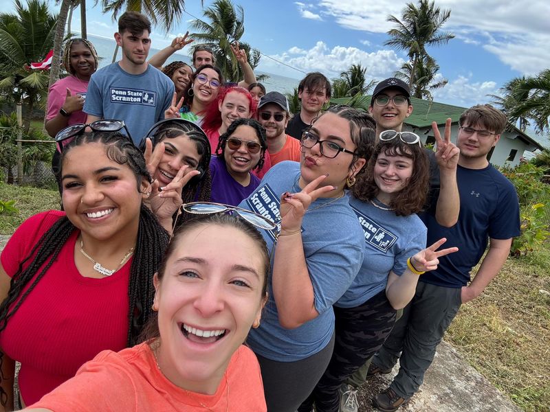 Students pose for a group selfie outside 