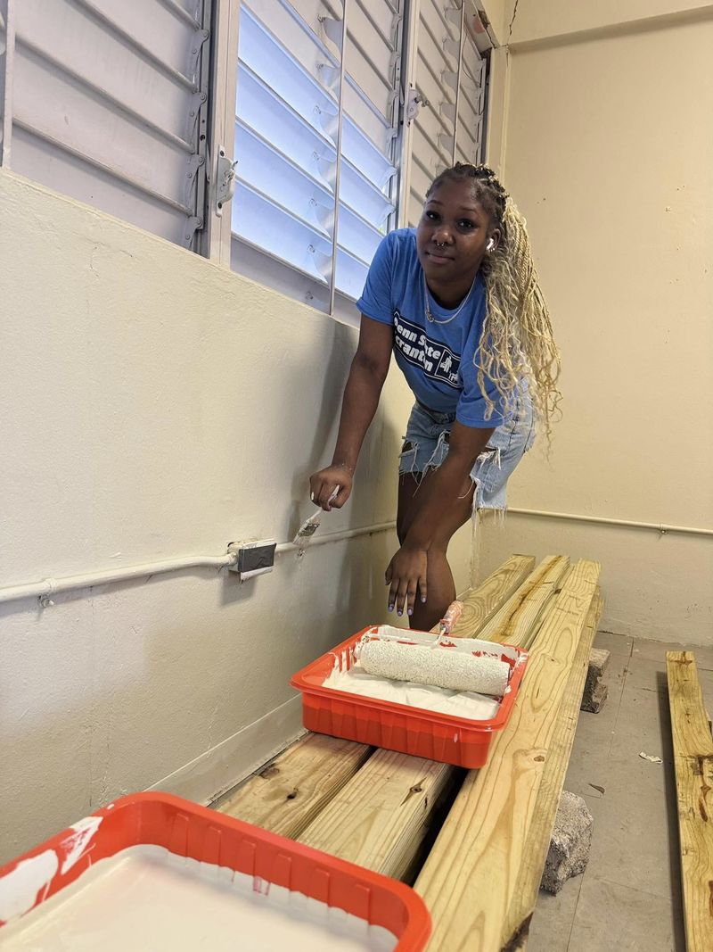 A female student paints a wall 