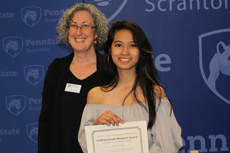 Head librarian Jennie Kneiss with award winner Alojjo holding her certificate