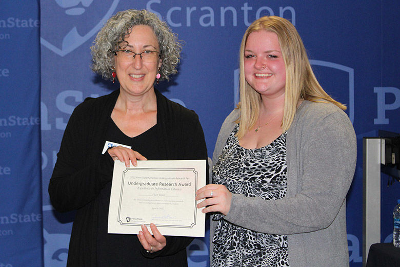 Clair Taylor accepts her award from Librarian Jennie Knies
