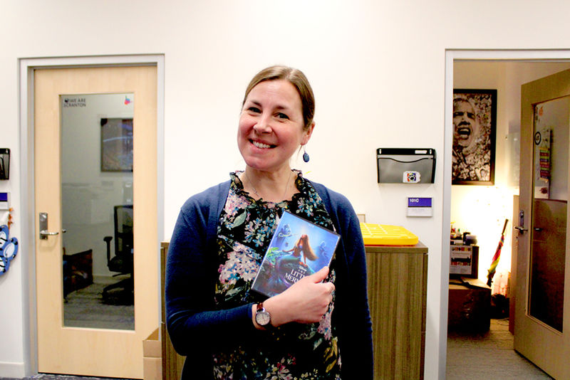 Diversity, Equity and Inclusion Coordinator Emily Glodzik shows off her borrowed DVD, "The Little Mermaid."