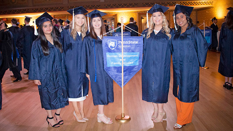 5 graduates near a HDFS banner