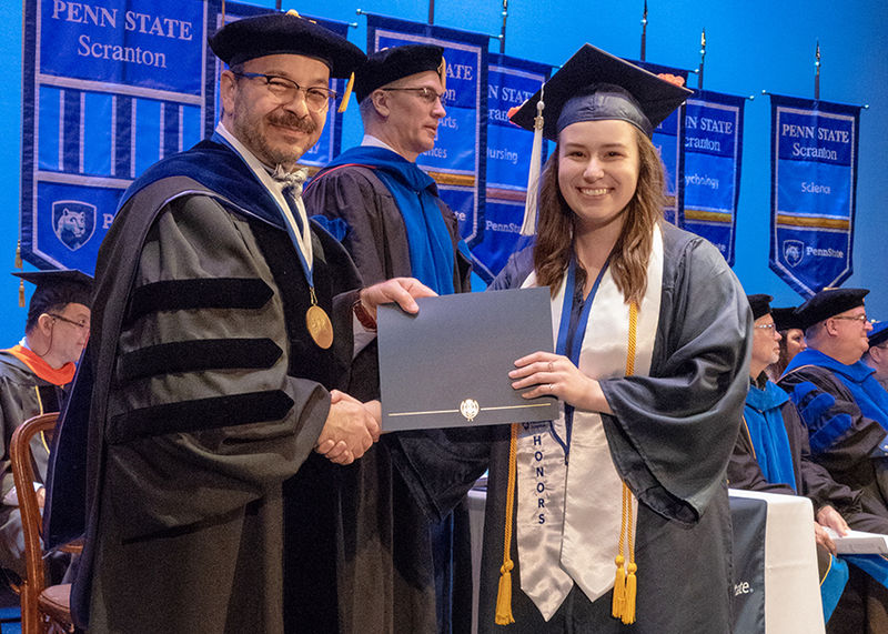 Honors student, Emma Pizzolanti, receiving her diploma from Dr. Marwan Wafa on stage during 2019 commencement.