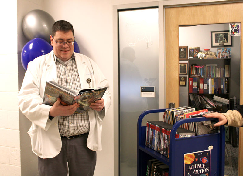 Michael Evans flips through a Star Trek book outside of his office that was available for borrowing during a recent Library Cart visit.