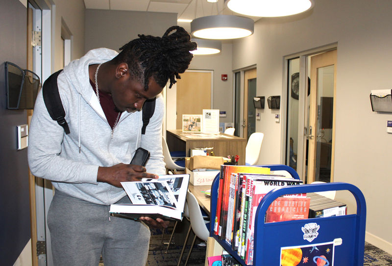 Student looks over book cart selections