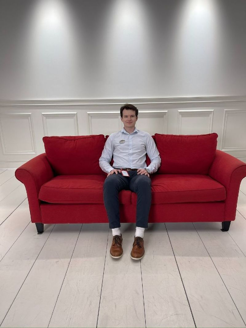 A student sits on a red couch