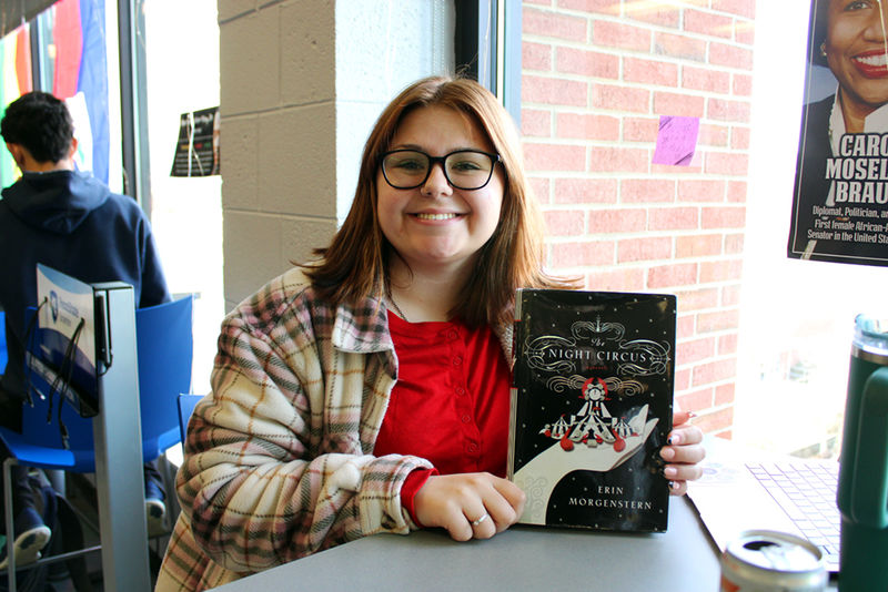 Student Kiera Langan smiles while showing off her book of choice "The Night Circus".