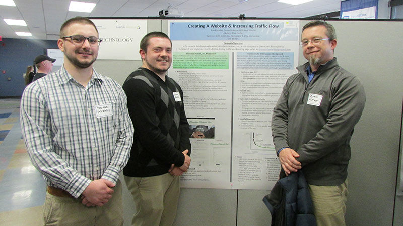 three students with research poster