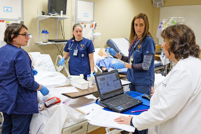 3 students and 1 faculty in nursing sim lab