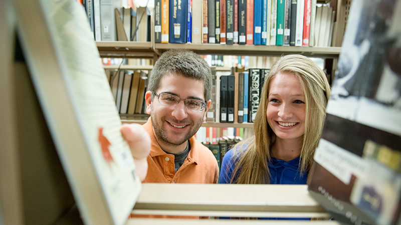 Two students check out books in the Penn State Scranton library.