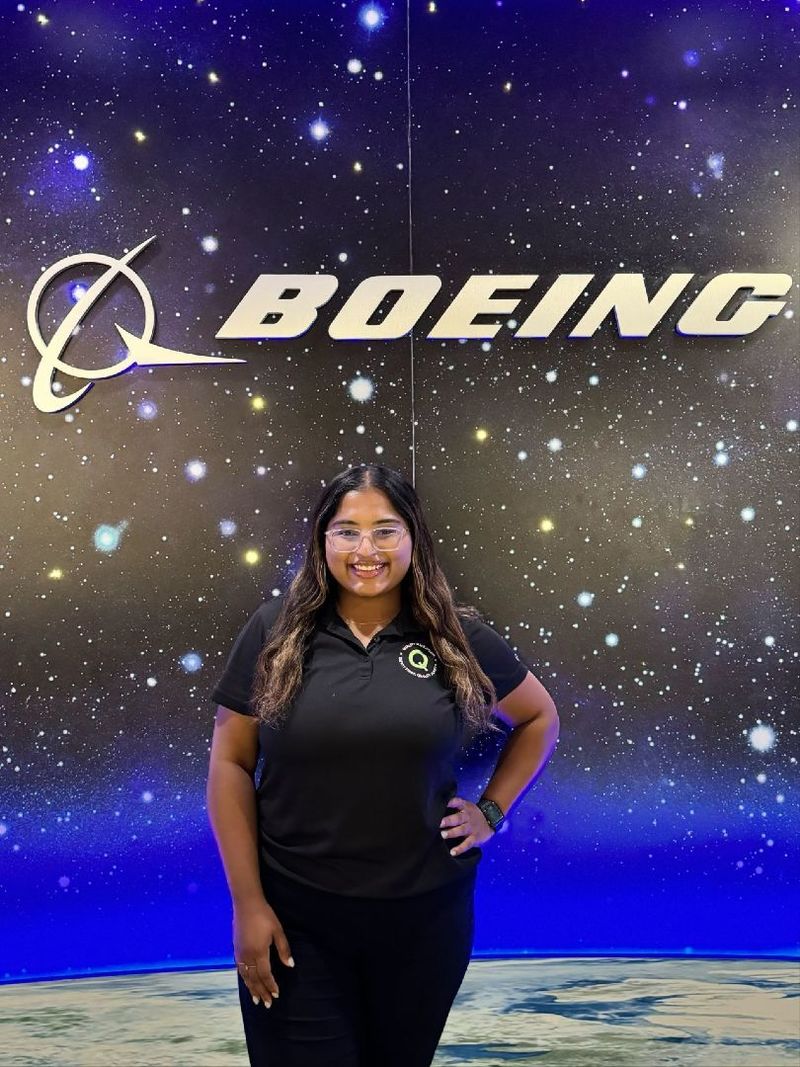 A student stands in front of a Boeing sign