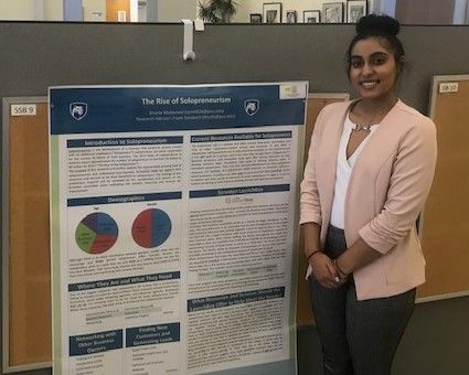 Student Shanie Mohamed standing near her poster at the Penn State Eastern Regional Undergraduate Research Symposium at Penn State Hazleton, 2019