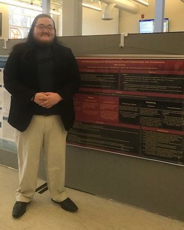 Student Michael Anthony standing near her poster at the Penn State Eastern Regional Undergraduate Research Symposium at Penn State Hazleton, 2019