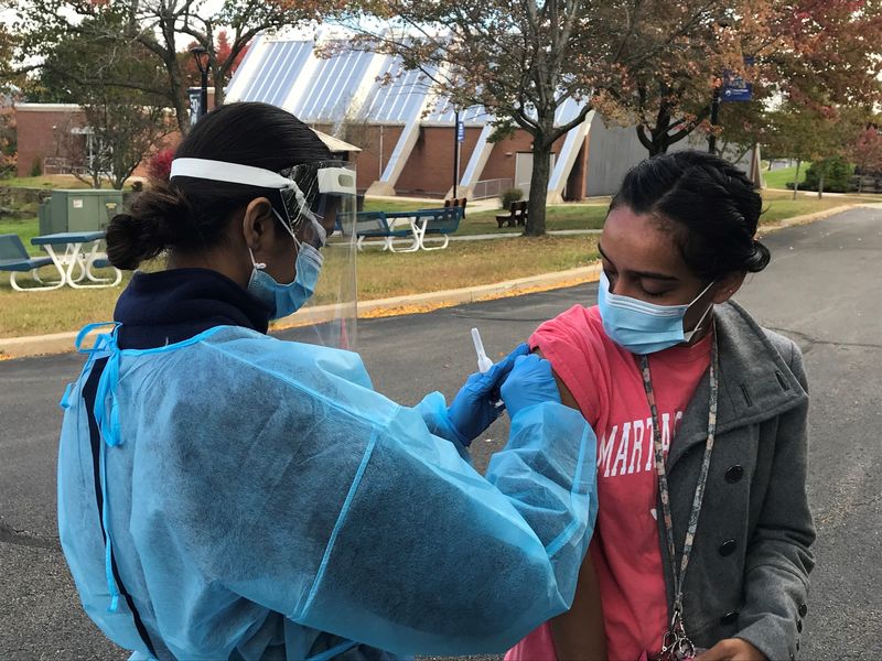 Campus nursing student prepares to give flu shot to student