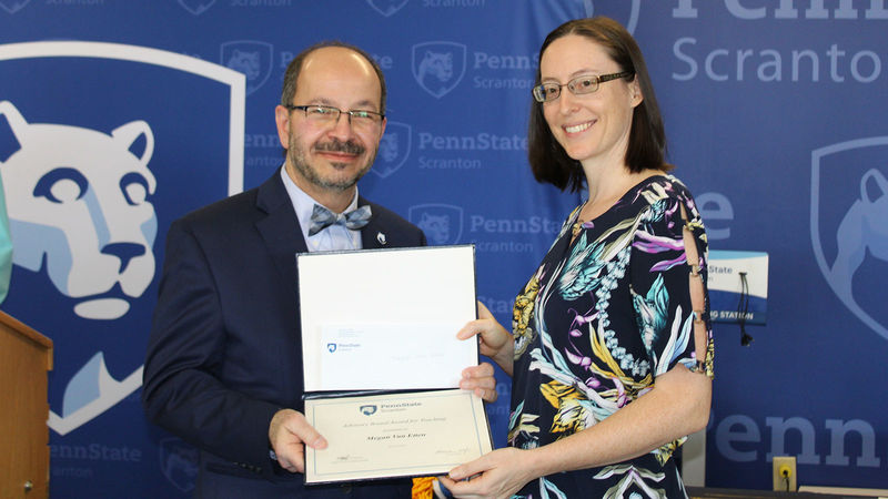 smiling man presents certificate to smiling woman
