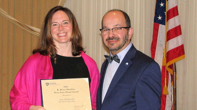 Julie Bialkowski receives award certificate from Chancellor Marwan Wafa