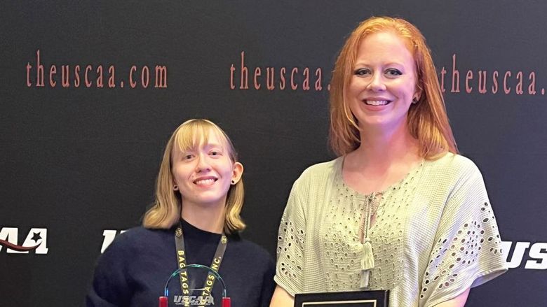 Megan Lucy and Sara Rinkunas holding their awards at USCAA awards ceremony