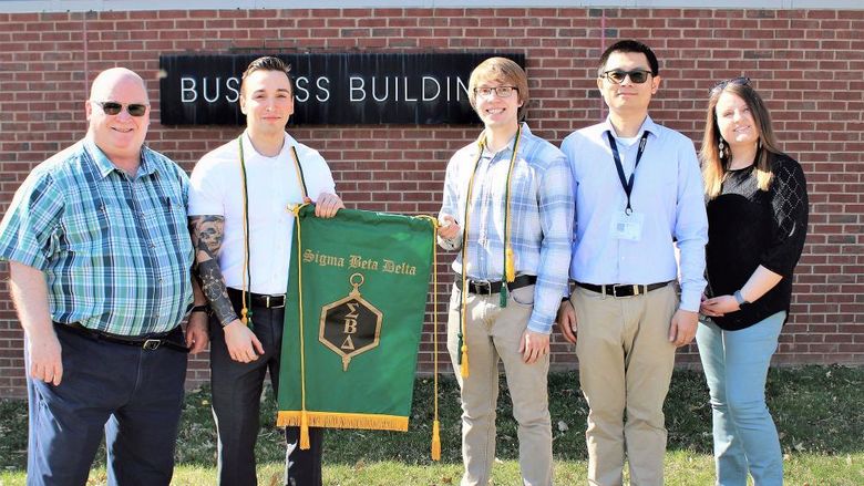 Delta Sigma Beta inductees pose for a photo outside of business building