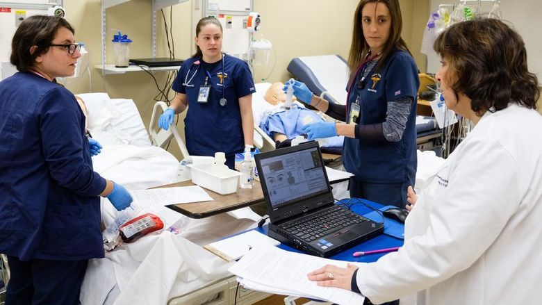 group of nurses receiving instruction in nursing sim lab