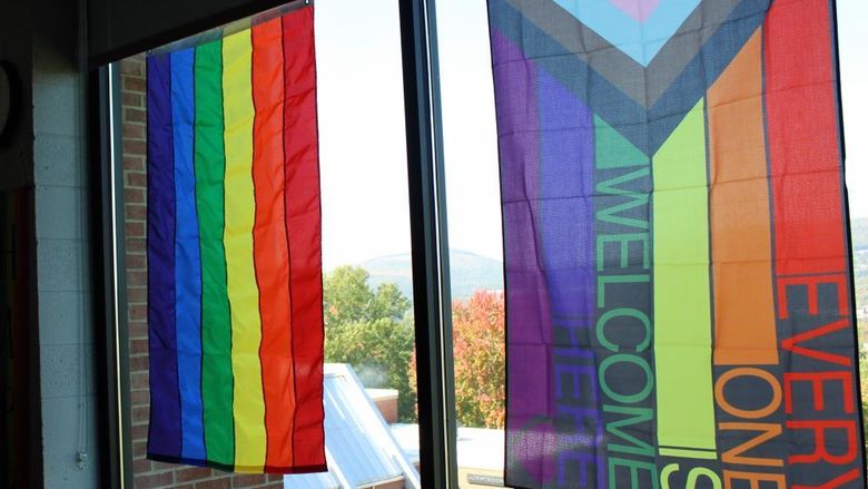 rainbow colored flags hand in the windows of The View Cafe on campus