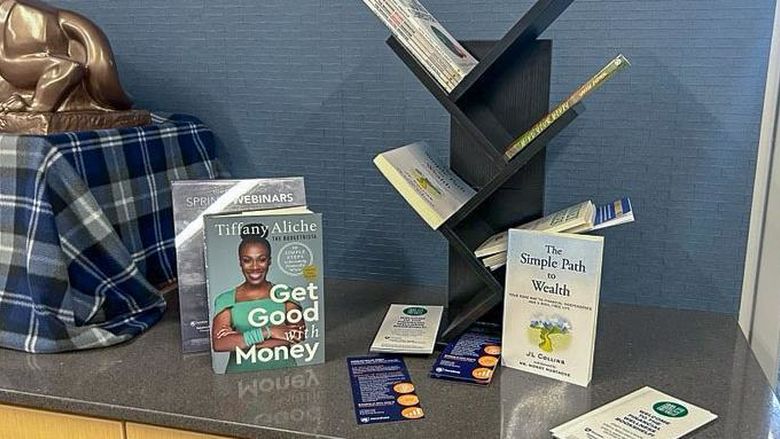 Books and brochures on financial wellness on a table in the admissions office