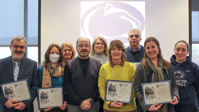 group of service award recipients holding their paper certificates