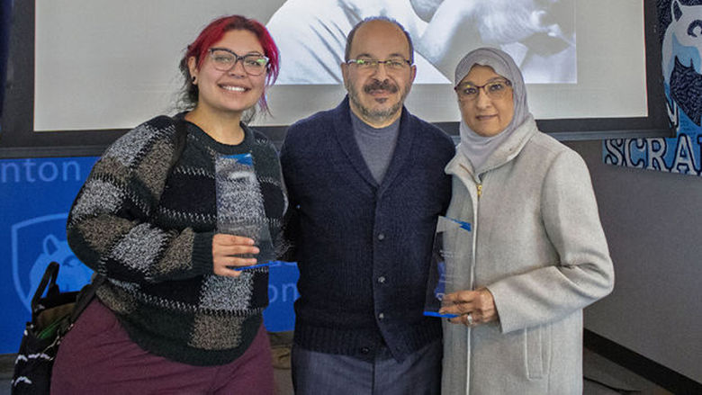 three people holding resin awards