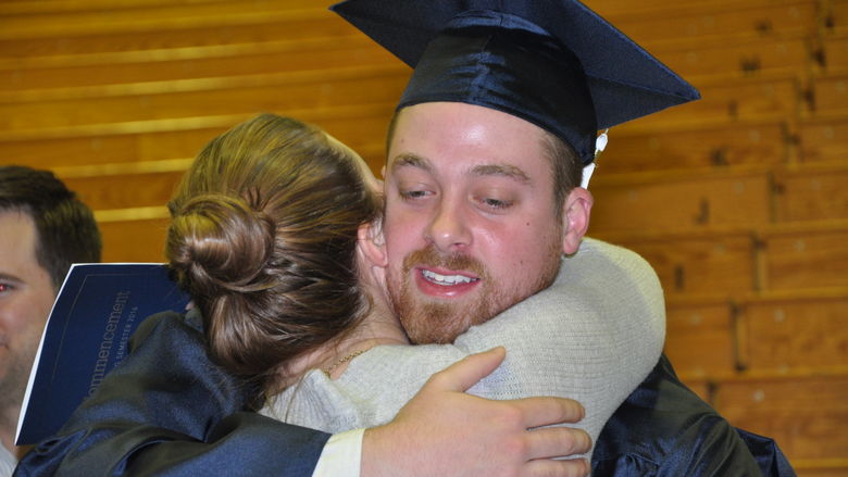 graduate hugging woman