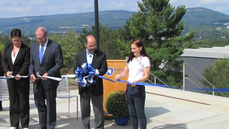 Several people cut a ribbon to dedicate the new Penn State Scranton patio
