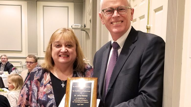 Janet Melnick receiving award from Provost Nick Jones
